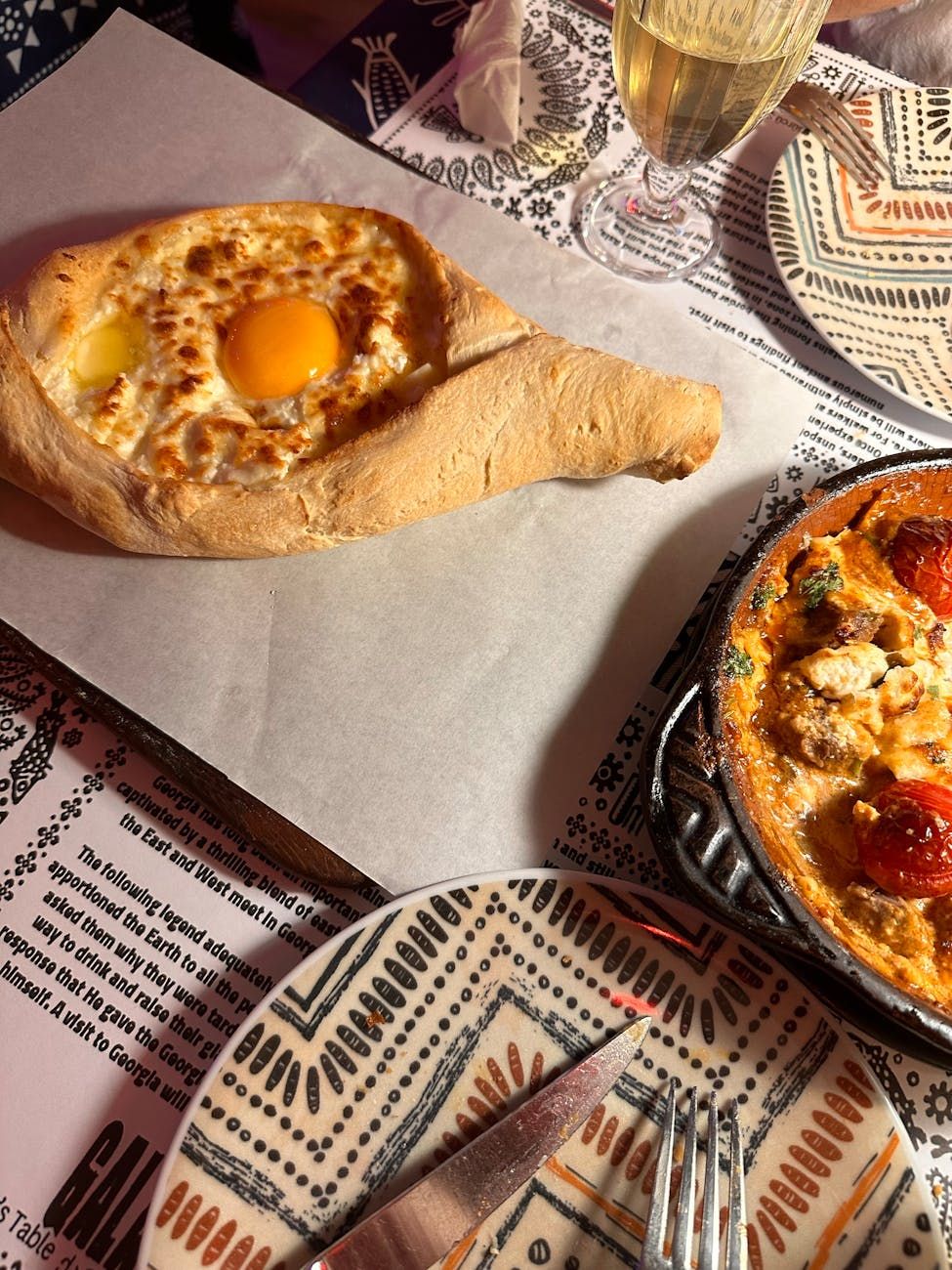 Adjarian Khachapuri, georgische Küche, mit Käse gefülltes Brotboot, traditionelles georgisches Gebäck, Khachapuri-Rezept, Sulguni-Käse, Eigelb-Belag, kaukasische Küche, authentische georgische Gerichte, selbstgemachter Khachapuri